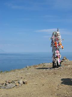 Een paal met een hoop dankjewels bovenop de klif bij Goboy